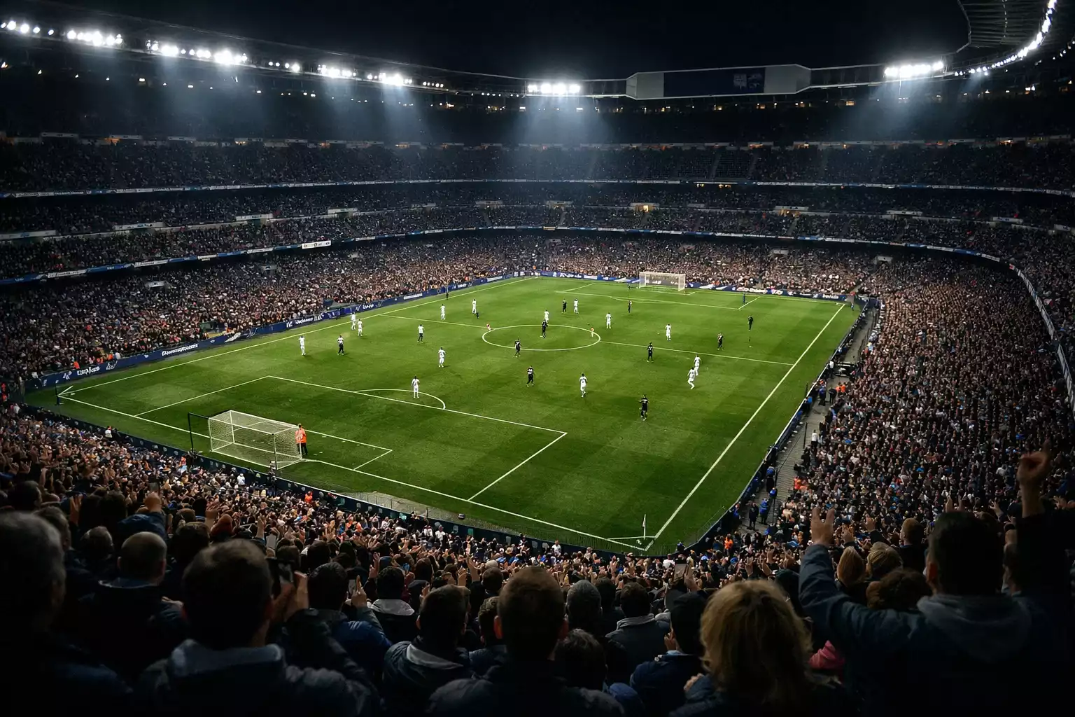 Estadio de fútbol lleno de aficionados durante un partido nocturno con iluminación espectacular