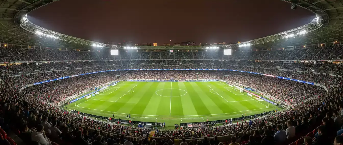 Vista panorámica de un estadio de fútbol español lleno de público bajo el cielo nocturno
